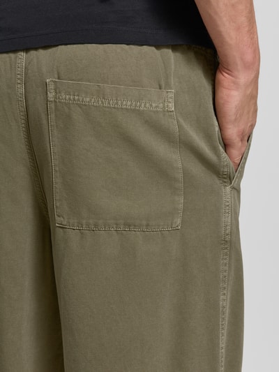 Männermodel trägt Jog Pants mit französischen Eingrifftaschen Modell 'LYCAZ' von American Vintage, reine Baumwolle, Detailaufnahme Rückansicht.