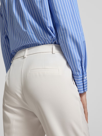 Frauenmodel trägt Hose aus Viskose-Mix mit Bügelfalten von Comma in Creme, glatte Textur, mit Eingrifftaschen, Nahaufnahme Rückansicht. Slim-Fit, Stretch-Anteil, Bundweite 36 cm, Innenbeinlänge 72 cm.