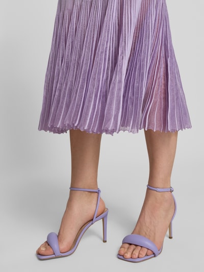 Frauenmodel trägt Strickkleid aus Rippstrick von BOSS in Lavendel, Transparente Plisseefalten, Knielang, Nahaufnahme Unterkörper.