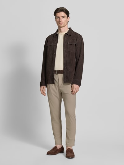 Männermodel trägt Slim Fit Hose mit Paspeltaschen am Gesäß von CRUNA in Beige mit Stretch-Anteil, Ganzkörperansicht von vorne.