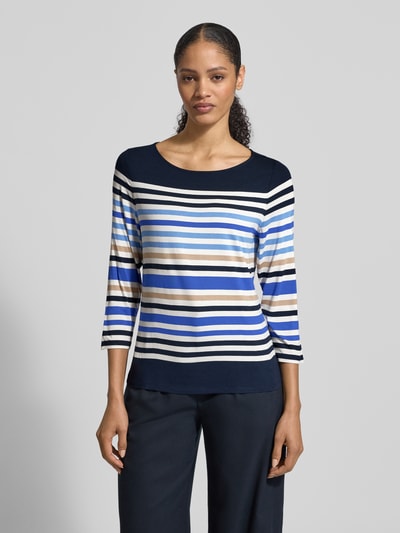 Modelka prezentuje Longsleeve aus Viskose-Elasthan-Mix mit 3/4-Arm von Betty Barclay, krój regular fit, okrągły dekolt, długość pleców w rozmiarze 36: 60 cm, paski w odcieniach granatu, błękitu, beżu i bieli, tkanina gładka, widok na cały przód sylwetki.