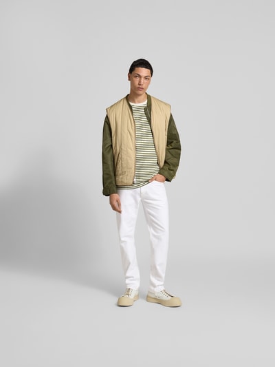 Männermodel trägt Straight Fit Jeans mit Stretch-Anteil von Closed in Weiß mit Kontrastnähten, 5-Pocket-Design, Ganzkörperansicht von vorne.