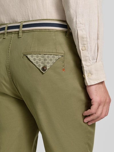 Männermodel trägt Chino mit Gürtel und Eingrifftaschen Modell 'WARREN' von Scotch & Soda in Grün, Baumwoll-Mix, Nahaufnahme Rückansicht.