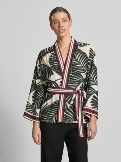 Frauenmodel trägt Kaftan aus Viskose-Mix mit floralem Allover-Print von Christian Berg Woman Selection in Creme, Grün und Rot, taillierte Passform, abnehmbares Stoffband, Nahaufnahme Oberkörper.