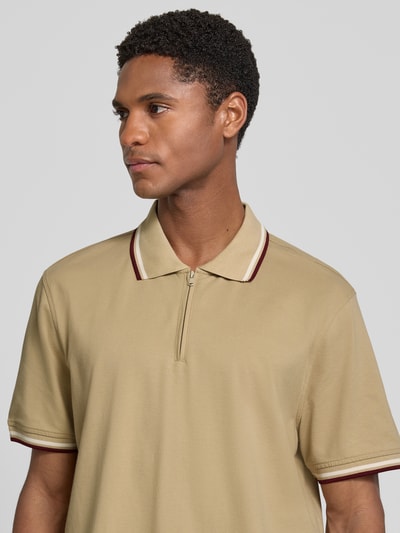 Männermodel trägt Slim Fit Poloshirt mit Kontraststreifen und Reißverschluss von MCNEAL aus Baumwoll-Elasthan-Mix, Nahaufnahme Oberkörper.
