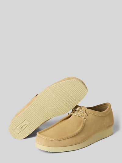 Produktfoto, Loafer mit Statement-Prägung Modell 'Wallabee' von Clarks in hellem Beige, abgerundete Form, strukturierte Sohle, sichtbare Ziernähte, Schafthöhe 7 cm, Schaftweite 11 cm, Absatzhöhe 3 cm, Schnürverschluss, Produktdetail auf grauem Hintergrund.