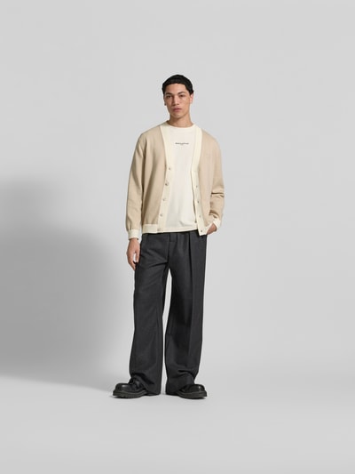 Männermodel trägt Regular Fit T-Shirt aus Baumwolle von MAISON KITSUNÉ in Offwhite, kurzärmelig, Rundhals, Label-Stitching, Ganzkörperansicht von vorne.