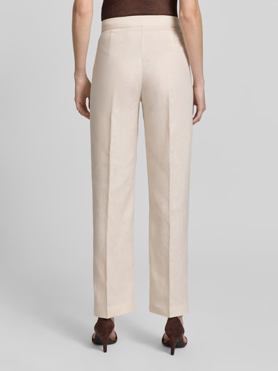 Frauenmodel trägt Stoffhose mit Bügelfalte Modell 'BORELI' von Mango aus Reine Baumwolle in Beige, Slim-Fit, Ganzkörperansicht Rückansicht. Bundweite bei Größe 38: 34 cm, Innenbeinlänge 80 cm, Haken- und Reißverschluss.