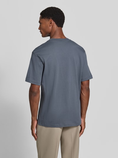 Männermodel trägt Regular Fit T-Shirt aus reiner Baumwolle von Lacoste in Grau mit glatter Textur, Ganzkörperansicht Rückansicht.