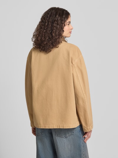Frauenmodel trägt Regular Fit Jeansjacke aus reiner Baumwolle Modell 'FLIMANE-1-D_B' von Hugo Blue in Beige mit Umlegekragen, Ganzkörperansicht Rückansicht.