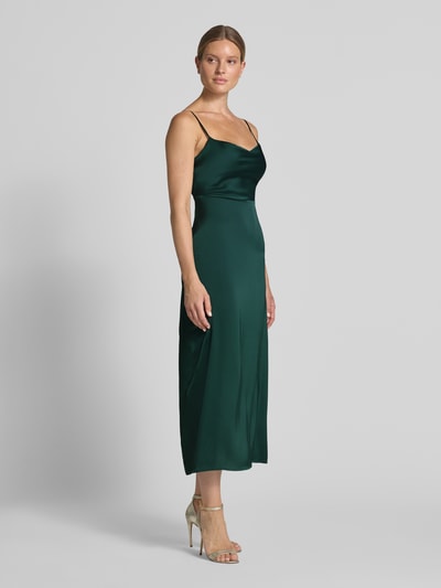 Frauenmodel trägt Abendkleid aus Satin Modell 'RAVENNA' von VILA in Dunkelgrün, glatte Textur, gerader Schnitt, Midikleid, Ganzkörperansicht von vorne.