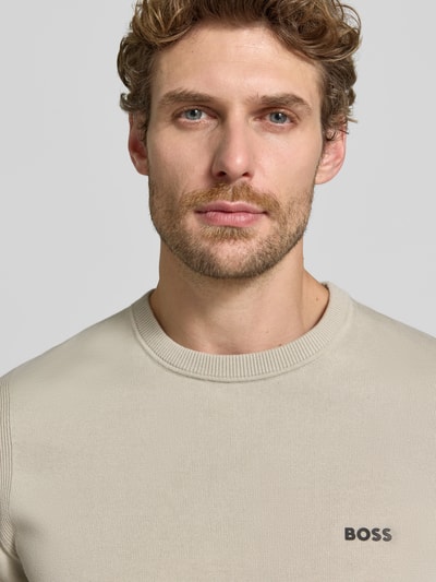 Männermodel trägt Regular Fit Pullover aus reiner Baumwolle Modell 'KN_Ever-X' von BOSS, cremefarbene Feinstrickstruktur, Nahaufnahme Oberkörper, Herren Pullover von BOSS Green.