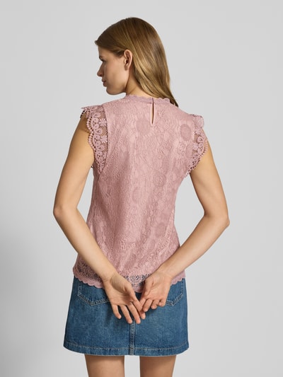 Frauenmodel trägt Shaped Fit Blusentop mit Spitzenbesatz Modell 'OLLINE' von Pieces, Optik: Unifarben, Passform: Shaped Fit, Muster: Floral, Label-Stitching-Applikation, Rundhals, 1-Knopf-Verschluss, Schlüsselloch-Rückenausschnitt, Materialverarbeitung: Spitze, zartes Rosa, feine florale Textur, Ganzkörperansicht Rückansicht.
