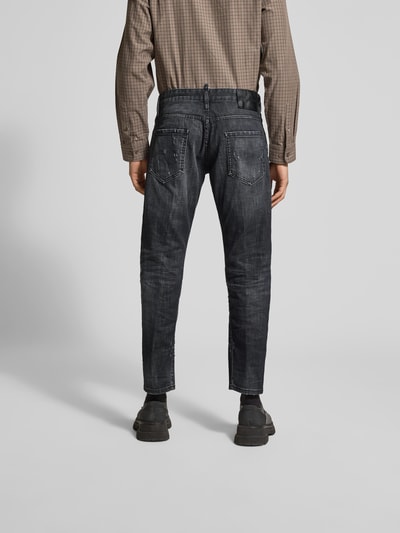 Männermodel trägt Slim Fit Jeans aus Baumwoll-Mix von Dsquared2 im Destroyed-Look, 5-Pocket-Design, dunkler Farbton, Ganzkörperansicht Rückansicht. Innenbeinlänge 44 cm, Bundweite 74 cm bei Größe 50.