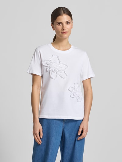 Frauenmodel trägt Regular Fit T-Shirt mit Rüschenbesatz von Comma aus reiner Baumwolle, weiß, Rundhalsausschnitt, Ganzkörperansicht von vorne. Rückenlänge bei Größe 36: 56 cm.