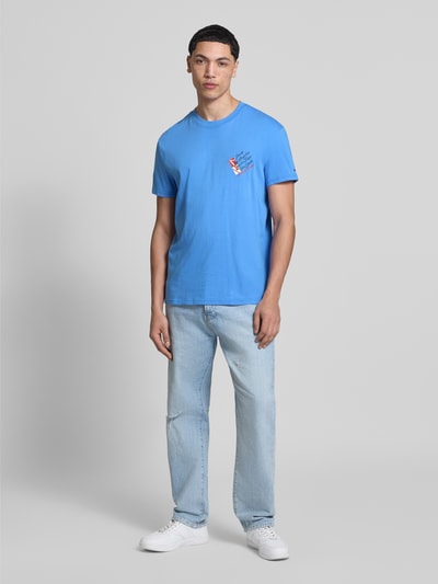 Männermodel trägt Regular Fit T-Shirt aus reiner Baumwolle von Tommy Jeans in Unifarbe Blau, kurzarm, Jersey, Ganzkörperansicht von vorne