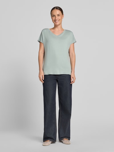 Frauenmodel trägt T-Shirt aus Viskose-Elasthan-Mix mit V-Ausschnitt von Christian Berg Woman, Relaxed-Fit, Kappärmel, Rückenlänge 63 cm, Ganzkörperansicht von vorne.
