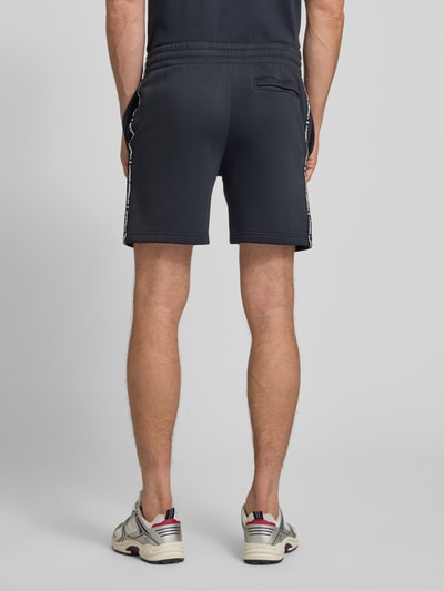 Männermodel trägt Shorts mit elastischem Bund und Label-Stitching von Under Armour in Dunkelblau, Regular Fit, Baumwoll-Mix, Ganzkörperansicht Rückansicht.