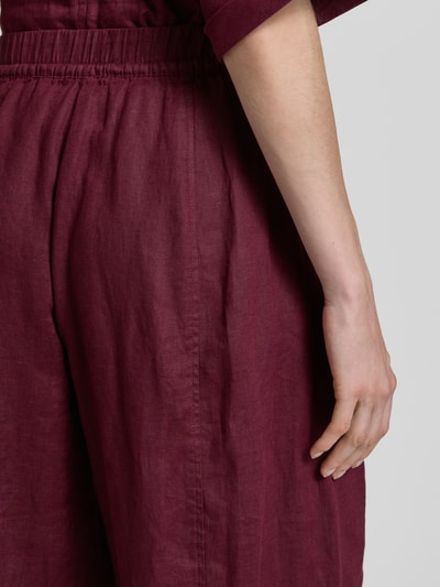 Frauenmodel trägt Leinenhose in verkürzter Passform mit elastischem Bund von Christian Berg Woman, bordeauxrot, reine Leinenstruktur, Detailaufnahme