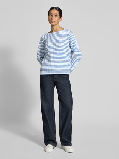 Frauenmodel trägt Relaxed Fit Pullover in Strick-Optik Modell 'Gresh' von Opus aus reiner Baumwolle, gestreift in Blau und Weiß, Rundhalsausschnitt, Jeans, Ganzkörperansicht von vorne.