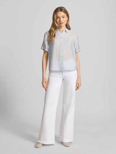 Frauenmodel trägt Relaxed Fit Bluse aus Modal-Mix mit Seiden-Anteil Modell 'MINA' von Samsøe Samsøe, hellblau, glatte Textur, lockerer Schnitt, Halbarm und Hemdblusenkragen, kombiniert mit weißer Hose, Ganzkörperansicht von vorne. Damen Bluse, Rückenlänge 62 cm, Ärmellänge 21 cm.