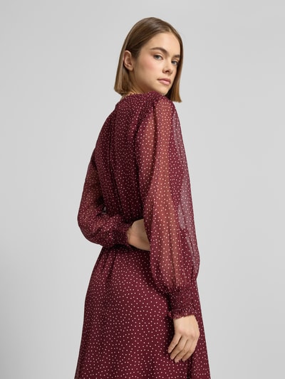 Frauenmodel trägt tailliertes sukienki casualowe z półprzezroczystego szyfonu, model 'Tailliertes Freizeitkleid mit tiefem V-Ausschnitt Modell MARIETTE' von Pepe Jeans, efekt: jednolity kolor, wzór w kropki, długość midi, długi rękaw, elastyczne zakończenia rękawów, aplikacja z metką i wyhaftowanym logo, wiązanie w talii, widok z tyłu.