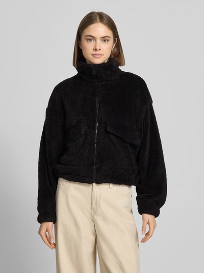 Frauenmodel trägt Loose Fit Fleecejacke mit Stehkragen Modell 'ANNA CONTACT' von Only, unifarben schwarz, Kunstwebfell, Ganzkörperansicht von vorne.