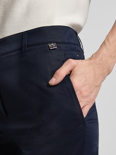Frauenmodel trägt Hose mit Bügelfalten und Eingrifftaschen von Marc Cain, Baumwoll-Viskose-Mix, Regular-Fit, Label-Detail, Nahaufnahme Oberkörper.