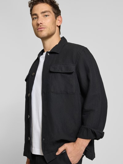 Mężczyzna nosi Relaxed Fit Hemdjacke aus Leinen-Baumwoll-Mix Modell 'LEROY' od SELECTED HOMME, czarny, jednolity, lniano-bawełniana struktura, długie rękawy, kieszenie na piersi, kołnierzyk wykładany, zapięcie na guziki, perspektywa z przodu, ujęcie do połowy ciała.