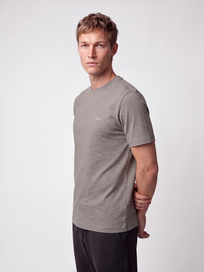 Mannenmodel draagt Regular Fit T-Shirt met klein logo-schrift van BOSS Green, effen, ronde hals, korte mouw, afgeronde zoom, katoenmix, vooraanzicht volledige lichaamsopname.