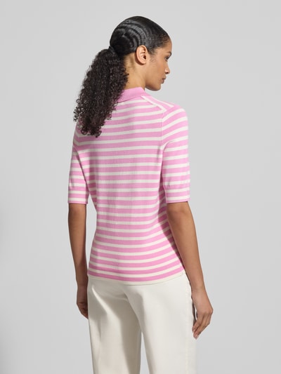 Frauenmodel trägt Poloshirt aus Viskose-Mix von Christian Berg Woman, rosa-weiß gestreift, gerader Schnitt, 1/2-Arm, Ganzkörperansicht Rückansicht.