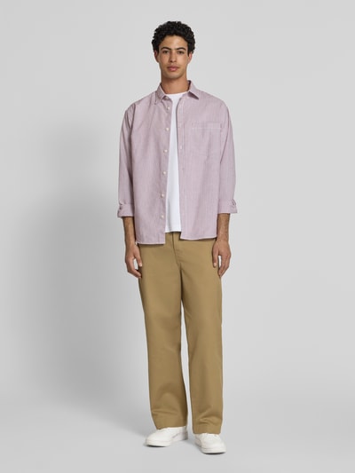 Männermodel trägt Hose mit Gesäßtaschen Modell 'Denison' von Carhartt Work In Progress in Beige, Relaxed-Fit, Material-Mix, Ganzkörperansicht von vorne.