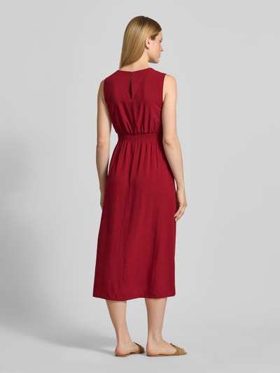 Frauenmodel trägt Damen Midikleid aus Viskose-Mix mit Leinen-Anteil Modell 'Daria' von MSCH Copenhagen in Rot, A-Linie, elastisches Taillenband, Ganzkörperansicht Rückansicht.