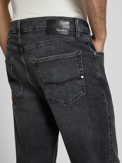 Männermodel trägt Regular Fit Straight Jeans aus Baumwoll-Lyocell-Mix Modell 'CASH' von Pepe Jeans in denimlook met labelpatch en label in reliëf, 5-pocketmodel, knoop- en ritssluiting, riemlussen, twill-materiaalverwerking, detailaufnahme achterzijde.