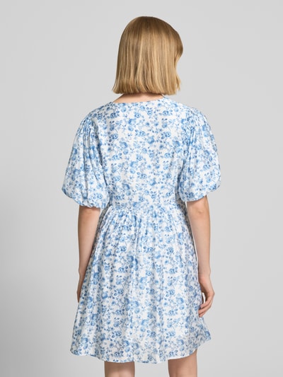 Frauenmodel trägt tailliertes Freizeitkleid aus Viskose-Mix Modell 'BLISS' von Vero Moda mit Optik:Allover-Muster, Mini-Länge, Ballonärmeln, feine Webstruktur, Ganzkörperansicht Rückansicht.
