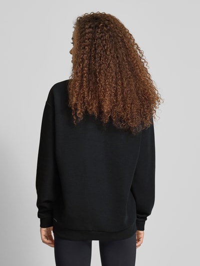 Frauenmodel trägt Relaxed Fit Poloshirt mit Lyocell-Anteil von PUMA in Schwarz, elastischer Material-Mix, Langarm, Logo-Detail, Ganzkörperansicht Rückansicht