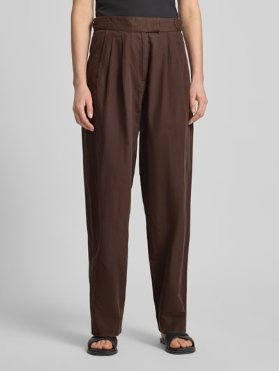 Frauenmodel trägt Wide Leg Hose mit Eingrifftaschen Modell 'QUINN' von Scotch & Soda, brauner Baumwoll-Leinen-Mix, Nahaufnahme Oberkörper bis Füße, Damen Hose.