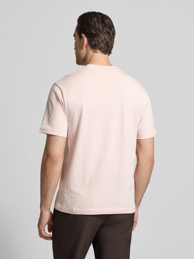 Mannelijk model draagt Regular Fit T-Shirt uit pure katoen van Lacoste in effen lichtroze met logo-patch, korte mouw, rugaanzicht.