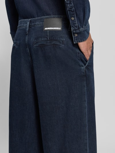 Männermodel trägt dunkelblaue Baggy Jeans aus reiner Baumwolle Modell 'Kaavo' von ARMEDANGELS, Detailaufnahme, Herren Baggy Jeans von ARMEDANGELS.
