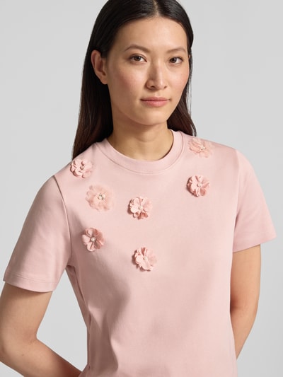 Frauenmodel trägt T-Shirt mit floralen Applikationen von Christian Berg Woman in Rosa, Reine Baumwolle, Gerader-Schnitt, Rundhalsausschnitt, 1/2-Arm, Damen T-Shirt; Nahaufnahme Oberkörper.