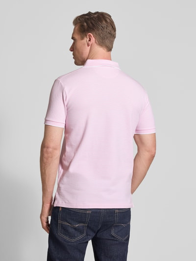 Männermodel trägt Slim Fit Poloshirt aus Baumwoll-Mix von Polo Ralph Lauren, Optik: unifarben gestreift, Ganzkörperansicht Rückansicht.