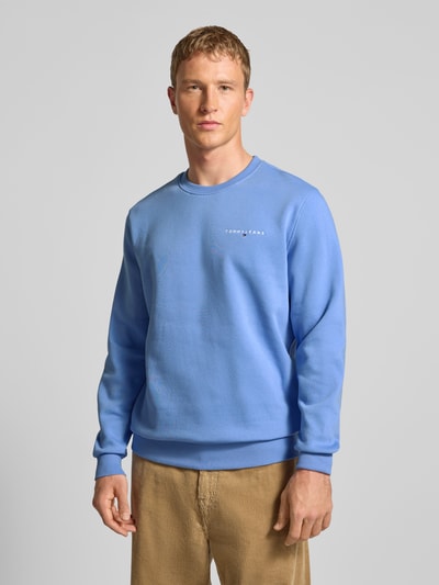 Männermodel trägt Regular Fit Sweatshirt aus Baumwoll-Mix von Tommy Jeans, Optik: Unifarben, Label-Stitching-Applikation, Rundhals, Langarm, gerippte Abschlüsse, Materialverarbeitung: Sweat, Ganzkörperansicht von vorne.