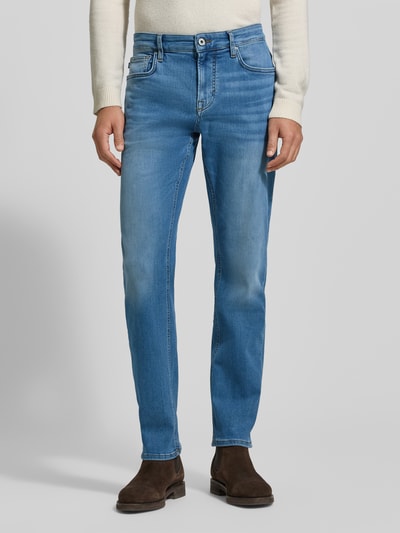 Mężczyzna nosi Jeansy z 5 kieszeniami Model 'Mitch' od JOOP! Jeans, mieszanka bawełny ze streczu, krój slim fit, zapięcie na guzik i zamek, niebieskie, logo, widok całej sylwetki z przodu.