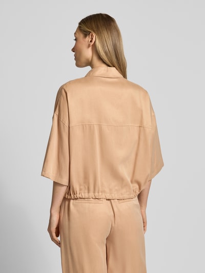 Modelka kobieca nosi Relaxed Fit Bluse aus Modal-Mix Modell 'Lainay' od Drykorn w kolorze jasnobeżowym, tunel w dole, krótki rękaw, długość tyłu 55 cm, długość rękawa 27 cm, widok całej sylwetki z tyłu.