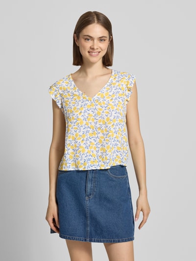 Frauenmodel trägt Regular Fit Blusentop aus reiner Viskose Modell 'BARRI' von Pieces, Two-Tone-Optik, abstraktes Muster, V-Ausschnitt, Popeline, gelbe und blaue Farbtöne, weiche Textur, Ganzkörperansicht von vorne.