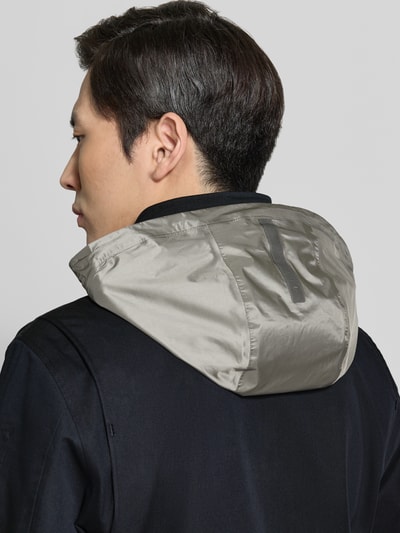 Männermodel trägt Jacke mit Stehkragen und Pattentaschen Modell 'DEFENDER' von G-LAB aus Baumwoll-Mix, Detailaufnahme Rückansicht.