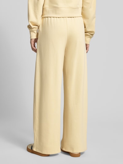 Männermodel trägt Wide Fit Sweatpants mit elastische Bund von Gina Tricot, bawełniany miks, krój wide fit, elastyczna talia, relaxed fit, całkowity widok z tyłu.