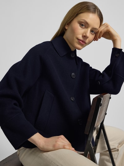 Vrouwenmodel draagt Relaxed Fit Jacke aus Woll-Mix mit Umlegekragen van Blonde No. 8 in donkerblauw, steekzakken, knoopsluiting, wolmix, maat 36: ruglengte 61 cm, schouderbreedte 45 cm, borstwijdte 47 cm, mouwlengte 55 cm. Nahaufnahme bovenlichaam.