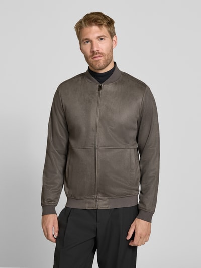 Męski model nosi Regular Fit Bomberjacke mit Stehkragen od Christian Berg Men, elastyczna mieszanka materiałów, zamek błyskawiczny, wpuszczane kieszenie, długość tyłu w rozmiarze M: 60 cm, długość rękawów w rozmiarze M: 67 cm, jednolity kolor, powierzchnia gładka, krój regular fit, Ganzkörperansicht von vorne.