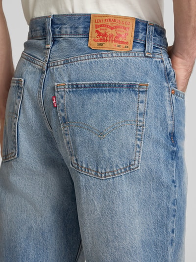 Männermodel trägt Loose Fit Jeans aus reiner Baumwolle Modell '565®' von Levi's®, hellblau, grobe Denim-Textur, Ganzkörperansicht Rückansicht.